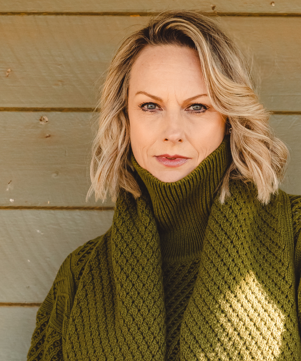 Vanessa Bell wearing an olive green knit sweater and scarf.