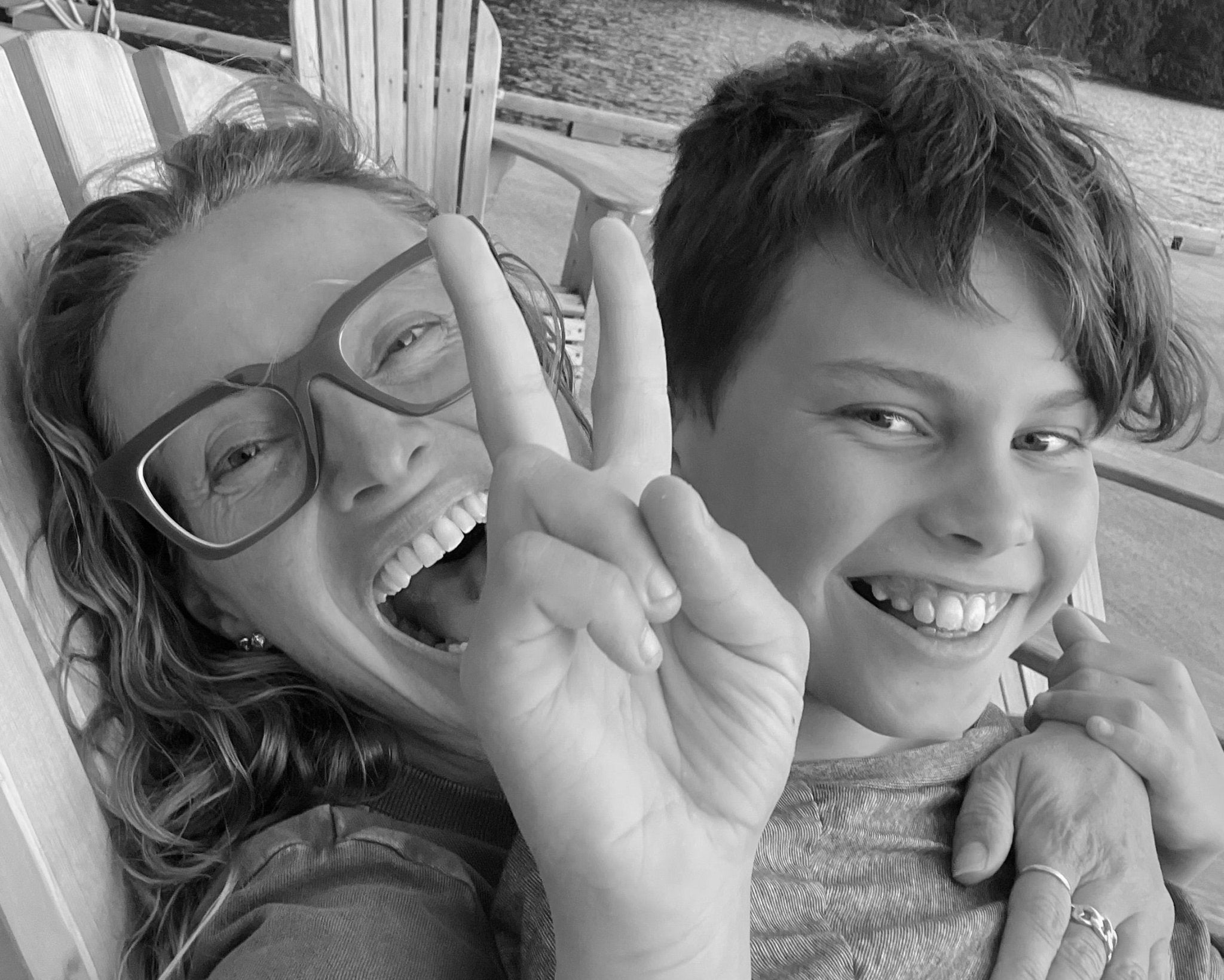 Woman and boy laughing at camera. Black and white image