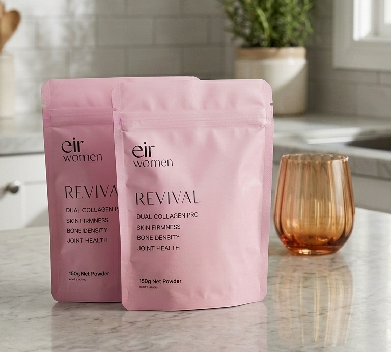 Two pink packages labeled 'Revival' on a kitchen counter with a glass of water.