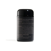 Load image into Gallery viewer, back of black glass vitamin bottle with pink writing 

